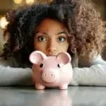 A Woman Is Staring At Her Piggi Bank