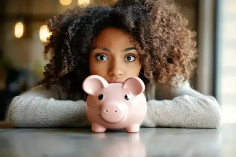 A Woman Is Staring At Her Piggi Bank